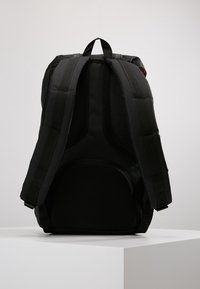 Czarny plecak z wyściełanym, usztywnionym tyłem i siateczkowymi akcentami. Posiada wyściełane ramiączka oraz wyraźne kontury dla wsparcia.