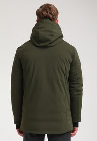 Parka verde impermeabile con colletto alto e cappuccio, polsini elasticizzati e una texture liscia e opaca. Presenta un design a taglio dritto.