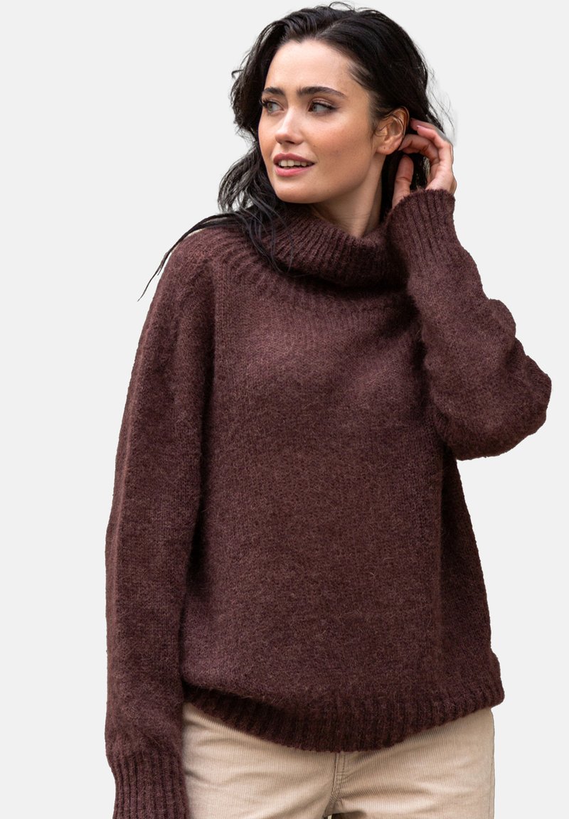 Brązowy, oversize sweter dzianinowy z golfem, prążkowymi mankietami i dołem. Miękka tekstura z lekko luźnym krojem i opadającymi ramionami.