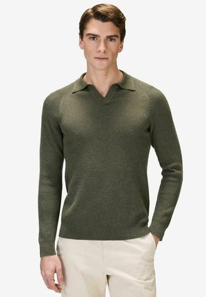 Olive green knit sweater with long sleeves, V-neck, and ribbed texture. Features a flat collar and is paired with cream-colored trousers.