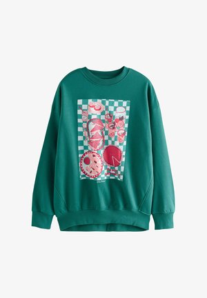 Sweatshirt vert avec un grand motif représentant des aliments sur un fond à carreaux. Le tissu est doux, avec une coupe ample et des poignets côtelés.