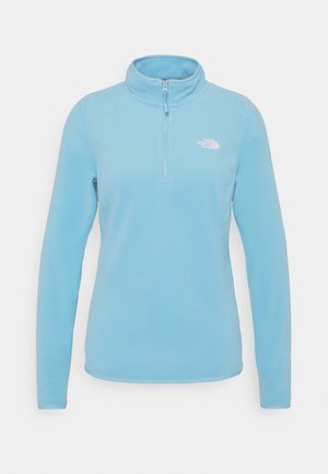 Lyseblå fleece-trøje med lange ærmer, kvart-lynlåslukning foran og lille hvid The North Face-logo på venstre bryst.