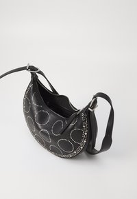 Black leather shoulder bag with circular studs, zippered closure, and a single strap. Features smooth texture and a curved silhouette.