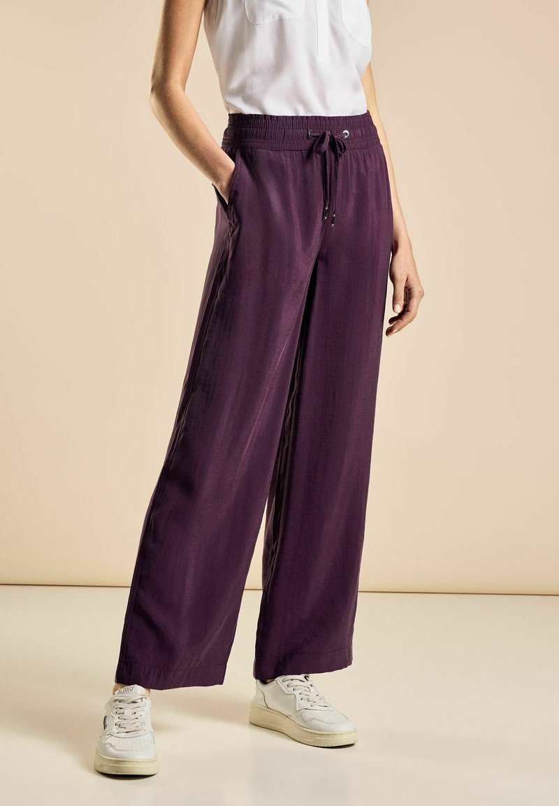 Pantaloni larghi viola con una vestibilità rilassata, dotati di una vita elastica e cordoncino. Tessuto leggero con una texture liscia.