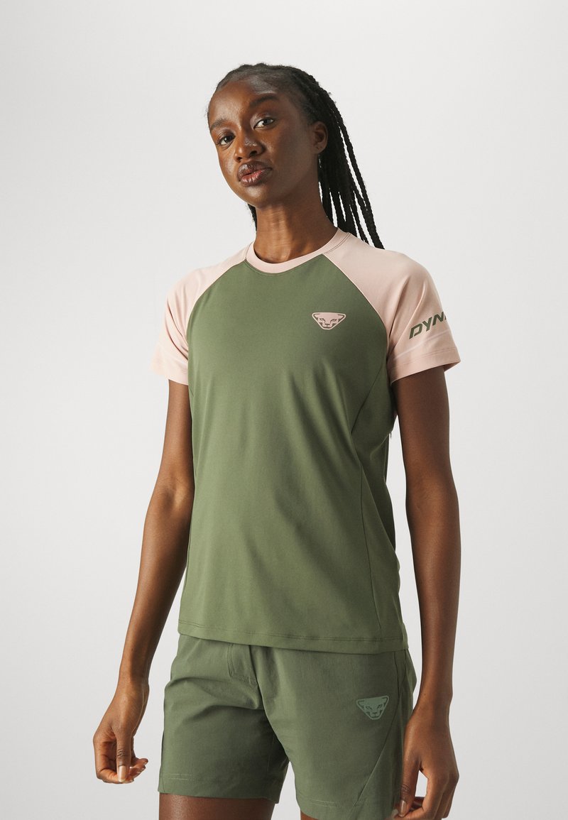 Camiseta deportiva verde oliva con mangas raglán de color rosa claro, un pequeño logo de marca en el pecho y tela suave y elástica.