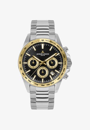 Nerezový chronograf s čiernym ciferníkom, zlatými akcentmi, tachymetrickým bezelom a tromi subciferníkmi. Strieborný náramok.