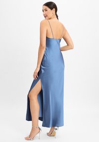 Satin-Nachthemd in Hellblau mit dünnen verstellbaren Trägern und einem hohen Schlitz bis zum Oberschenkel. Verfügt über eine glatte Textur und eine lockere Passform.