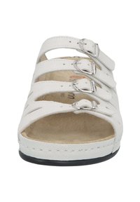 White sandal with four adjustable straps, silver buckles, open toe design, and a soft insole. Textured upper and black outsole.