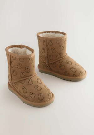 Brązowe zamszowe buty z miękkim białym wyściółką, z powtarzającym się wzorem królików. Krótkie, z okrągłym noskiem i gumową podeszwą.