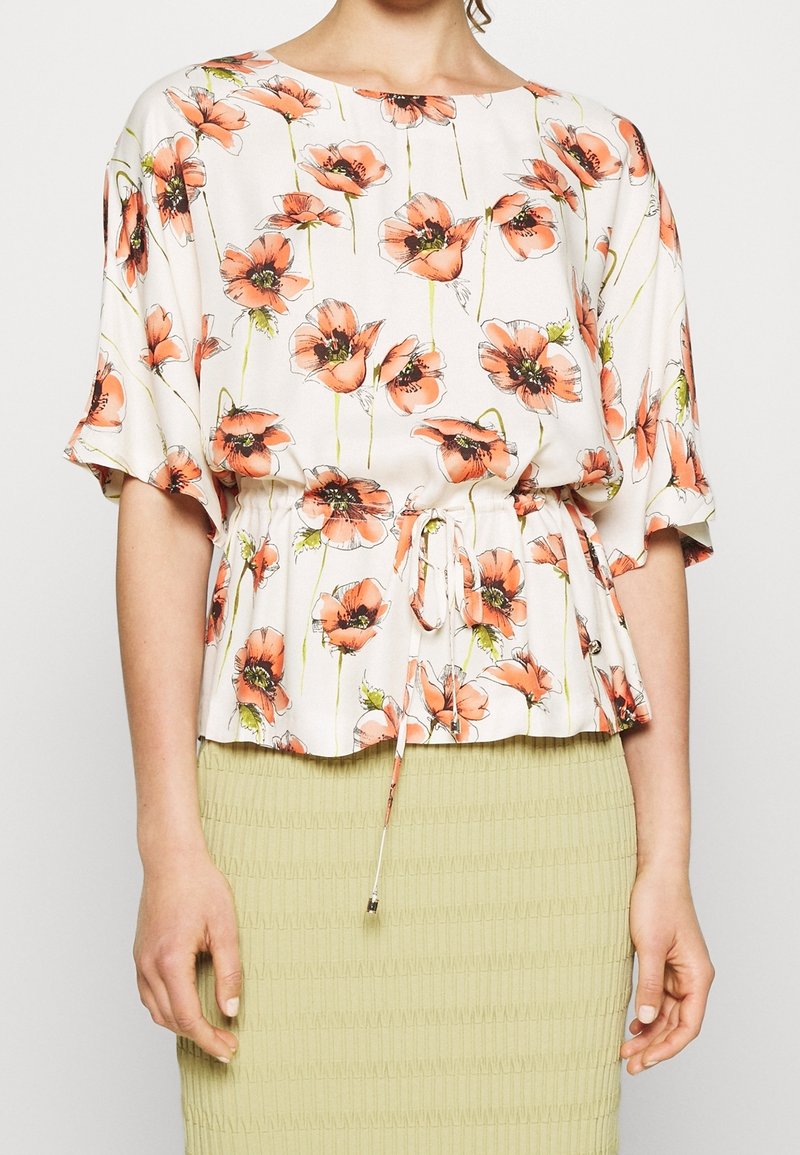 Kwiatowa bluzka w jasnej kremowej kolorze z pomarańczowym wzorem maków, z krótkimi rękawami, dopasowaną talią ze sznurkiem i luźnym krojem.