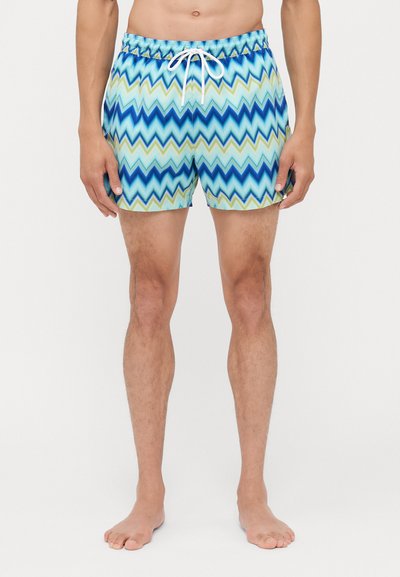 Badebukser med et zigzag mønster i blå, grønne og lyseblå nuancer. Fremstillet af letvægtsstof med elastisk talje og snøre.