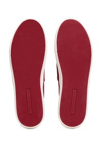 Rote Leinenschuhe mit einer strukturierten Gummisohle und weißen Akzenten. Mit einem Markenlabel in der Mitte der Sohle.