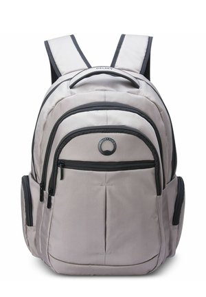Sac à dos en tissu gris clair avec plusieurs compartiments zippés, accents noirs, bretelles rembourrées et une poignée supérieure pour un transport facile.