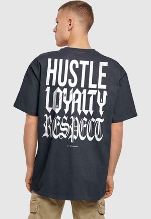 Sort oversized T-shirt med fed hvid tekst på ryggen: "HUSTLE LOYALTY RESPECT" i varierende skrifttyper. Korte ærmer og afslappet pasform.
