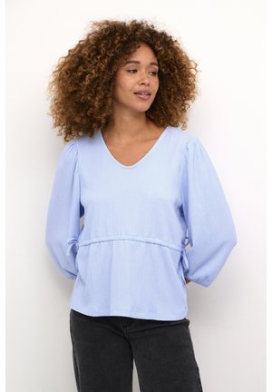 Blouse bleu clair à manches longues avec un col en V, en tissu texturé, épaules froncées et taille élastique pour un ajustement décontracté.