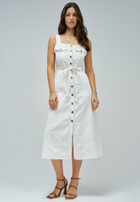 Witte denim midi-jurk met een vierkante halslijn, knopen aan de voorkant, twee borstzakken en een taille met riem. Heeft zijsplitten en contrasterende stiksels.