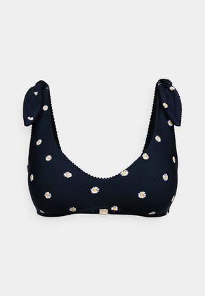 Top de bikini navy cu modele florale albe și galbene, având detalii cu șnururi pe bretele și margini dantelate de-a lungul decolteului.