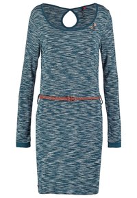 Långärmad klänning i texturerad tealtyg med ljusa vågmönster, med en nyckelhålsrygg och ett flätat bälte i midjan.