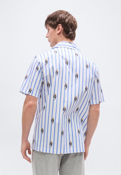 Πουκάμισο με κοντά μανίκια σε ανοιχτό μπλε και λευκές ρίγες, με ένα παιχνιδιάρικο μοτίβο μικρών, καρτουνίστικων φιγούρων με επίσημη ενδυμασία. Υλικό από βαμβάκι.