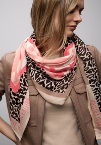 Écharpe imprimé léopard et rose avec des accents beige. Tissu doux en grande forme carrée, avec une bordure audacieuse et des détails textuels.