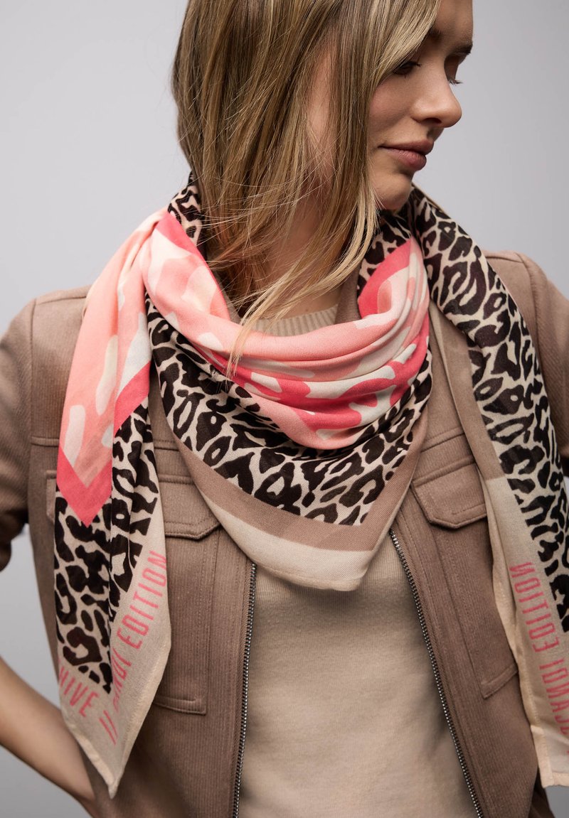 Écharpe imprimé léopard et rose avec des accents beige. Tissu doux en grande forme carrée, avec une bordure audacieuse et des détails textuels.