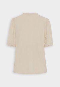 Blusa beige a maniche corte con una texture morbida, caratterizzata da maniche a sbuffo e un colletto piccolo. I bottoni ai polsini delle maniche aggiungono un tocco di dettaglio.
