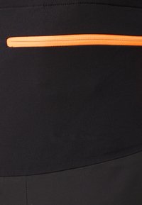 Schwarzer Stoff mit glatter Textur, der einen horizontalen orangefarbenen Reißverschluss im oberen Bereich aufweist. Einfaches Design, minimalistische Details.