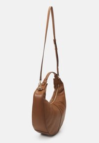 Brun læder hobo taske med en gylden lynlås, justerbar skulderrem og lille håndtag mod en ensfarvet hvid baggrund.