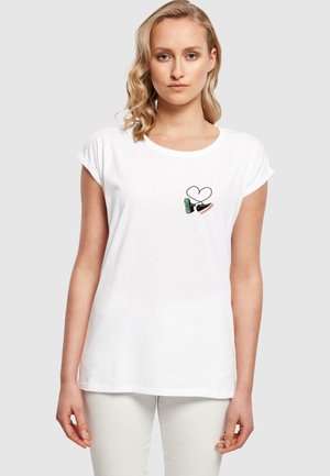 Tricou alb cu mânecă scurtă, cu decolteu rotund și un grafic imprimat care prezintă o inimă și desene colorate de pantofi pe pieptul stâng.