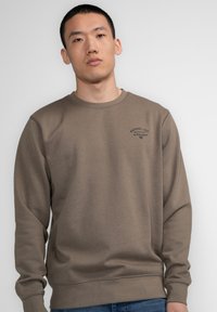 Bruine sweatshirt van katoen met een ronde hals, lange mouwen en een grafische print op de borst. De stof heeft een zachte structuur.