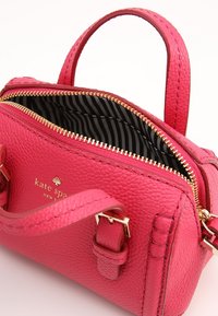 Bolso de mano de cuero texturizado en color rosa con dos asas, herrajes dorados y forro interior a rayas. Presenta un cierre con cremallera y detalle de logo.