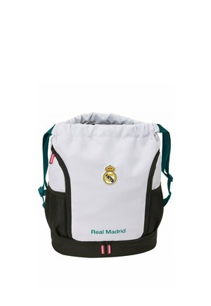 Biała i czarna torba sportowa Real Madrid z górnym ściągaczem, przednimi kieszeniami na zamek, bocznymi kieszeniami z siatki oraz zielonymi paskami na ramię.