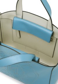 Blå skinnhåndveske med en lys beige innvendig, med unikt perforert design og kontrastfarget stropp. Funksjonell indre lomme.