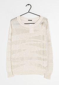 Pull en tricot beige clair à coupe décontractée, doté de motifs ajourés, d'un col rond et de poignets et ourlet côtelés. Suspendu à un crochet noir.