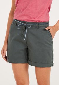 Donkergroene shorts met opgerolde cuffs, voorzien van zijzakken en een lichtblauwe trekkoord in de taille, gemaakt van een zachte stof.