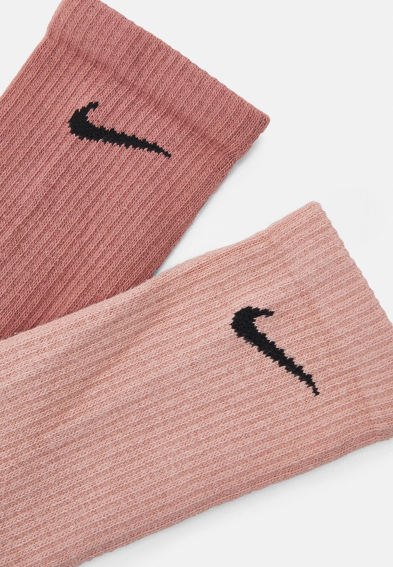 Skarpetki Nike w dwóch odcieniach różu, z prążkowaną teksturą, z czarnym logo Swoosh Nike na każdej. Miękki, elastyczny materiał dzianinowy.