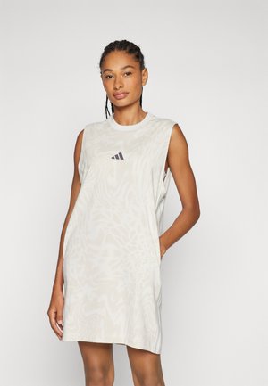 Light beige sleeveless dress with an abstract pattern, featuring a round neckline and an Adidas logo in dark purple on the chest.