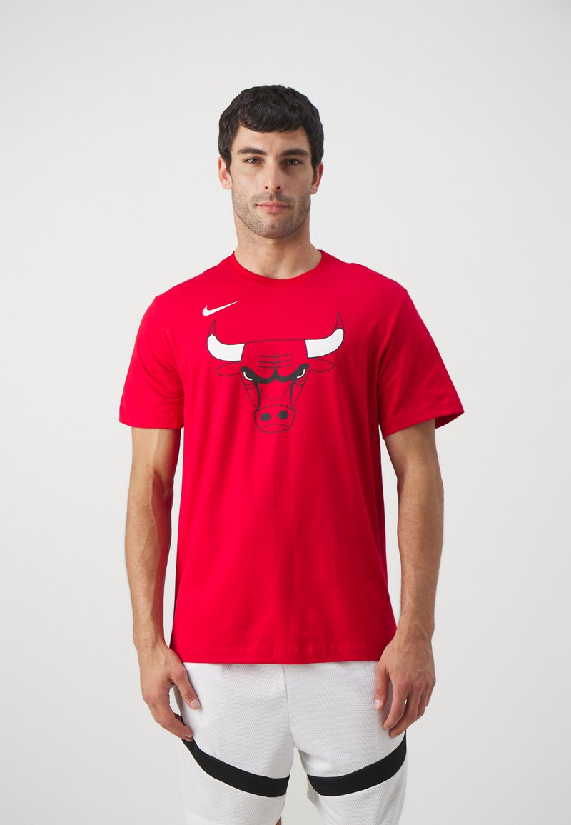 Rød bomulds T-shirt med et sort-hvidt Chicago Bulls okse-logo. Rund halsudskæring og korte ærmer. Sammen med hvide mesh shorts.
