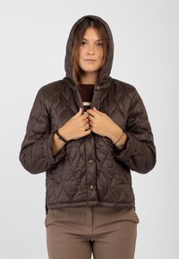 Giubbotto marrone trapuntato con cappuccio, caratterizzato da una trama uniforme e bottoni a pressione sul davanti. Il design include una vestibilità leggermente accorciata e tasche laterali.