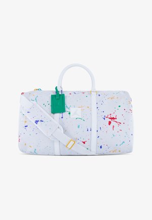 Bolso de viaje blanco con patrón de salpicaduras coloridas, que cuenta con dos asas, una correa desmontable y una etiqueta verde con un acento de logo.