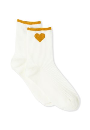Weiße gerippte Socken mit einem goldgelben Herzmuster auf einer Seite und einem kontrastierenden gelben, gerippten oberen Rand. Weiche Textur, mittlere Wadenlänge.