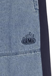 Pantalones cortos de mezclilla en azul claro con paneles laterales en azul oscuro, con un logotipo bordado de gráfico de llamas en negro en el bolsillo izquierdo.