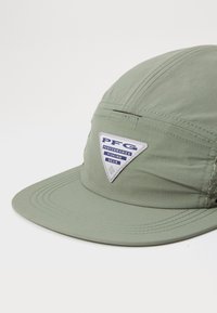 Green cap made of lightweight fabric, featuring a triangular patch with "PFG Performance Fishing Gear" and mesh accents on the sides.