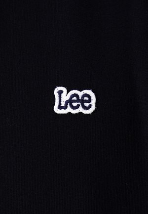 Zwarte stof met een klein wit en donkerblauw geborduurd "Lee"-logo in het midden.