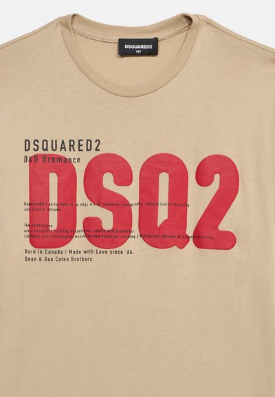Μπεζ μπλουζάκι με μεγάλο κόκκινο κείμενο "DSQ2" και μικρότερο μαύρο λογότυπο "DSQUARED2" καθώς και περιγραφικές φράσεις στο στήθος.