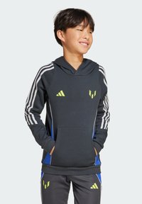 Hoodie noir avec capuche à cordon de serrage, rayures blanches sur les manches, accents jaunes et une poche avant. Associé à un pantalon gris avec des détails bleus.