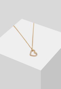 Collana dorata con un pendente a forma di cuore, decorato con strass trasparenti lungo il bordo, caratterizzata da una catena sottile.