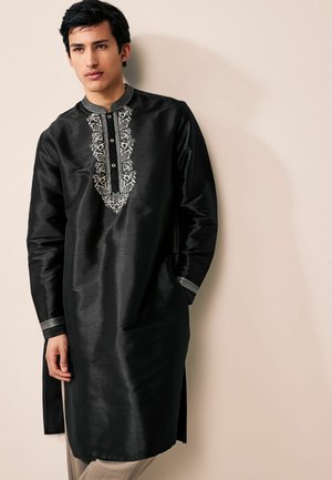 Black kurta made of smooth fabric, featuring intricate white embroidery along the placket and cuffs with a straight cut and side slits.