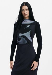 Rochie neagră cu mâneci lungi, realizată dintr-un material neted și închis la culoare, decorată cu modele abstracte gri, creând o siluetă elegantă și modernă.