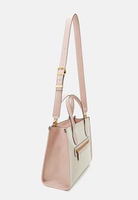 Sac fourre-tout structuré beige et rose avec doubles poignées, bandoulière réglable et poche zippée à l'avant. Matériau texturé et accents en métal doré.